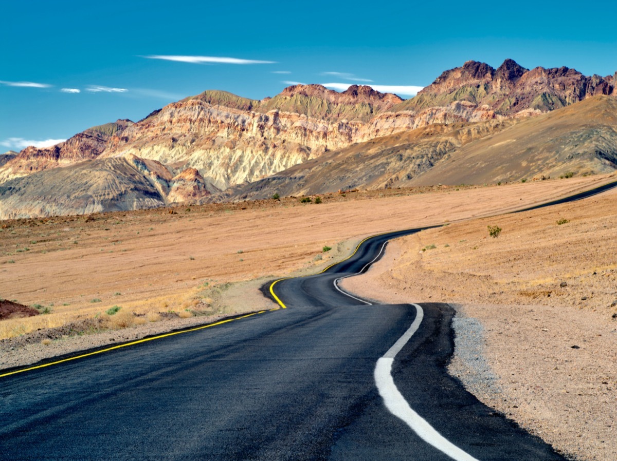 desert road leads into cliffs in california