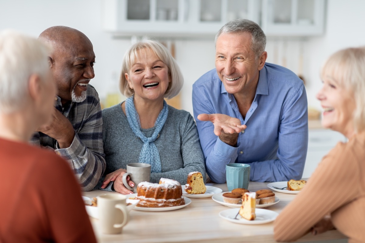 group of seniors sitting around a table telling old people jokes