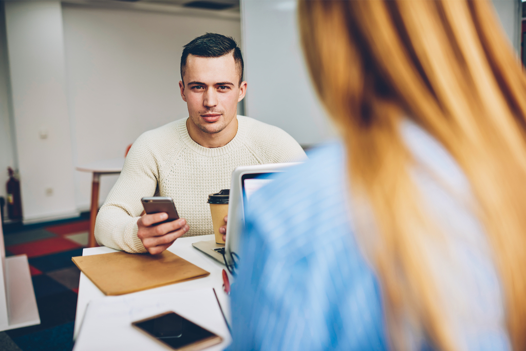 Man Checking Phone During Meeting Body Language That Kills First Impressions