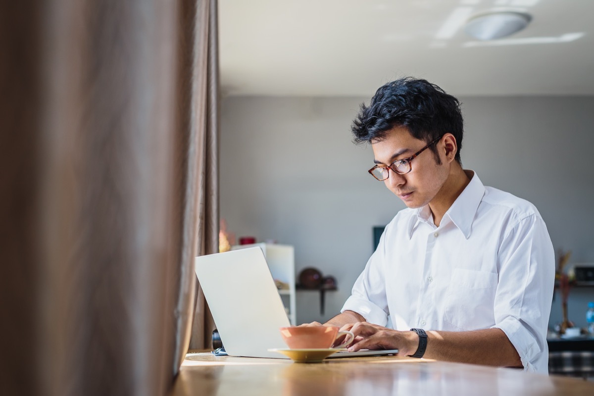 business man working with laptop computer while sitting in coffee shop cafe