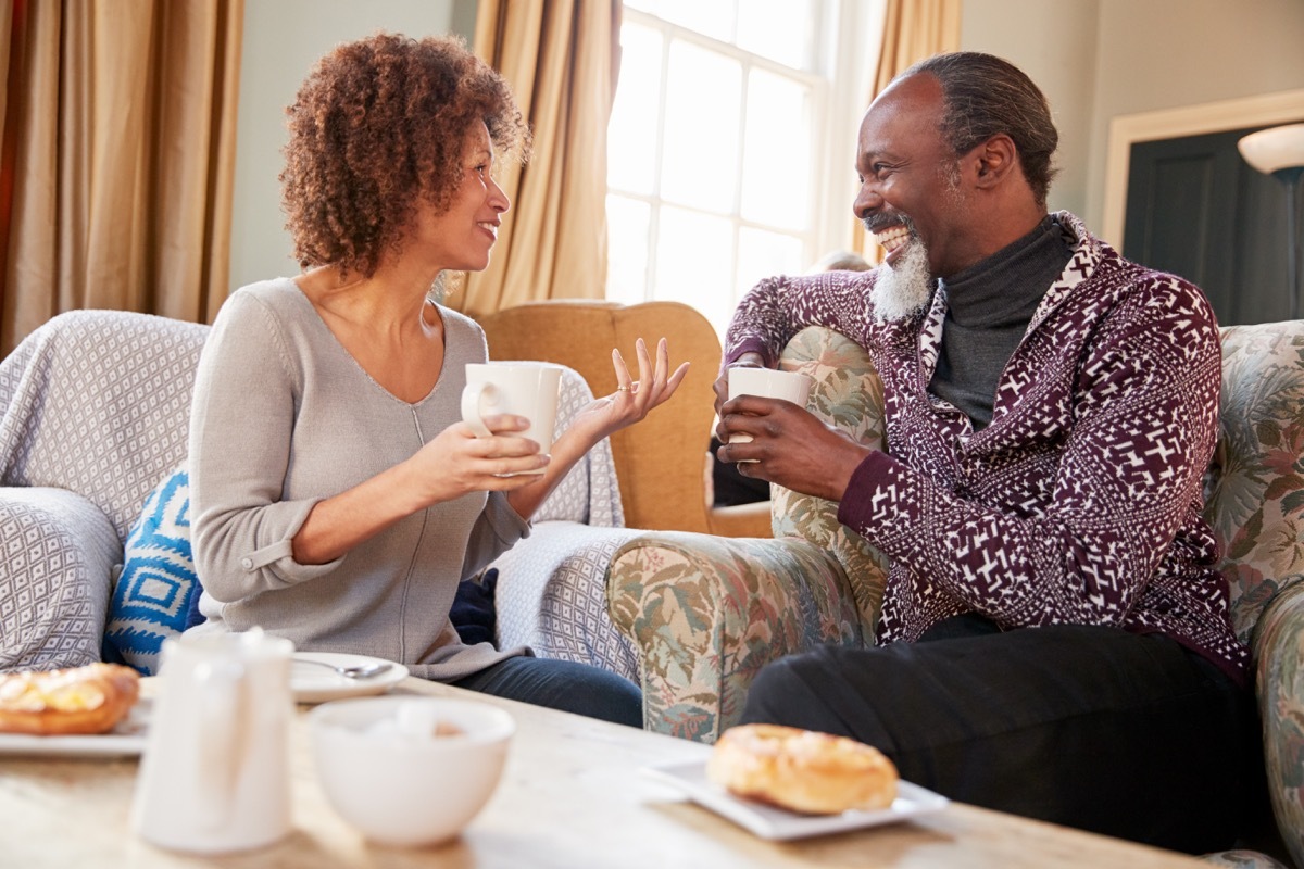 middle aged couple talking on couch