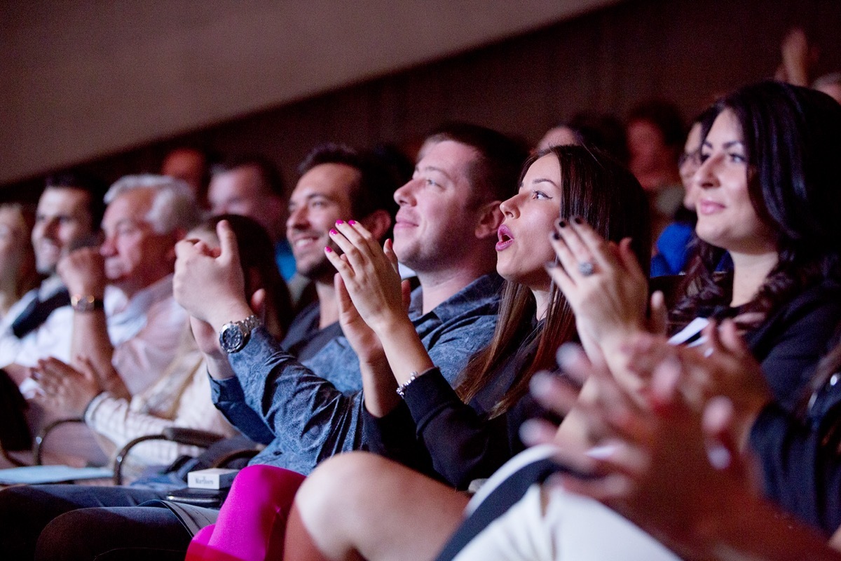 People applauding as they're watching a concert