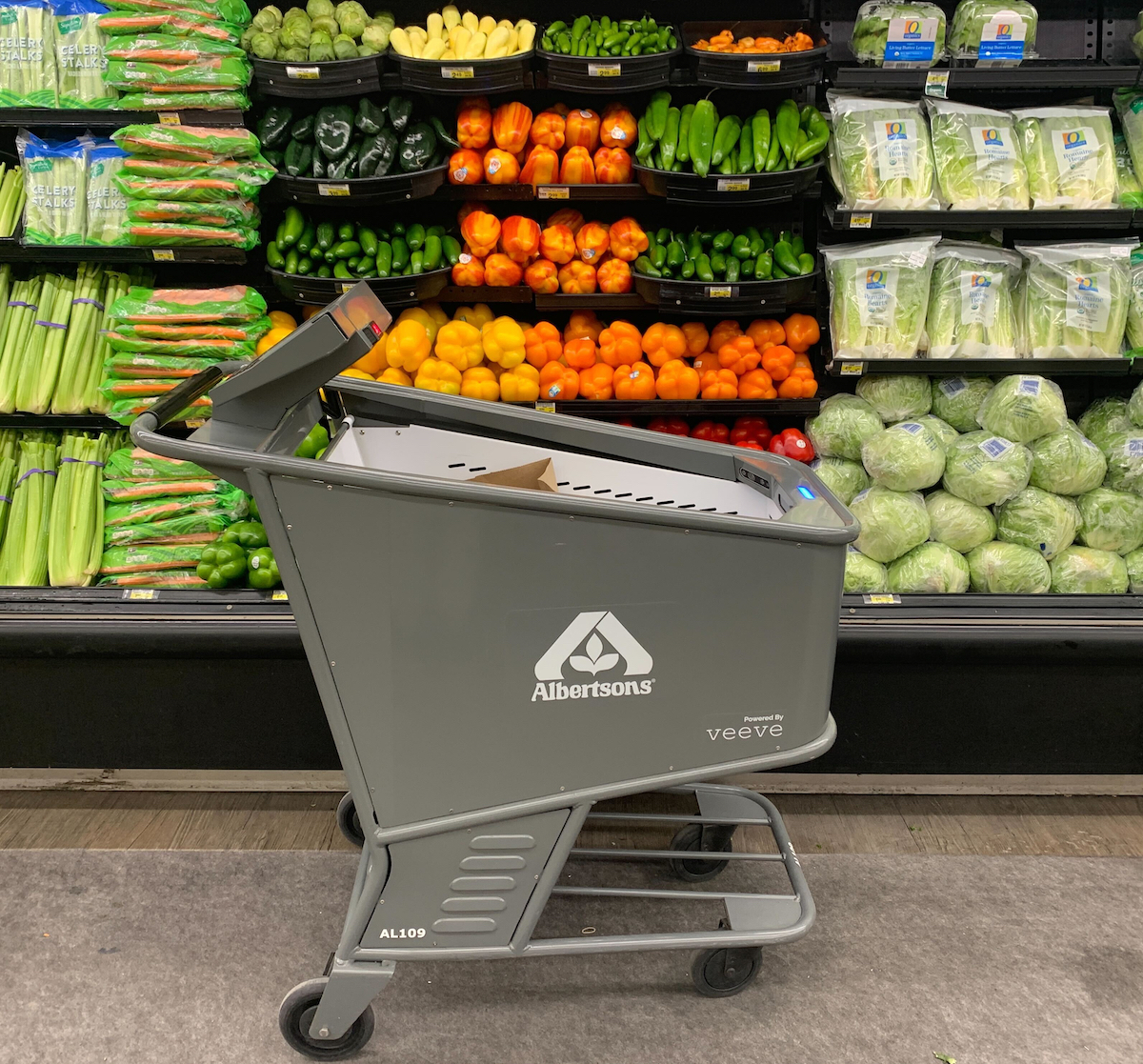 Product image of an Albertson's smart shopping cart made by Veeve in front of a produce display