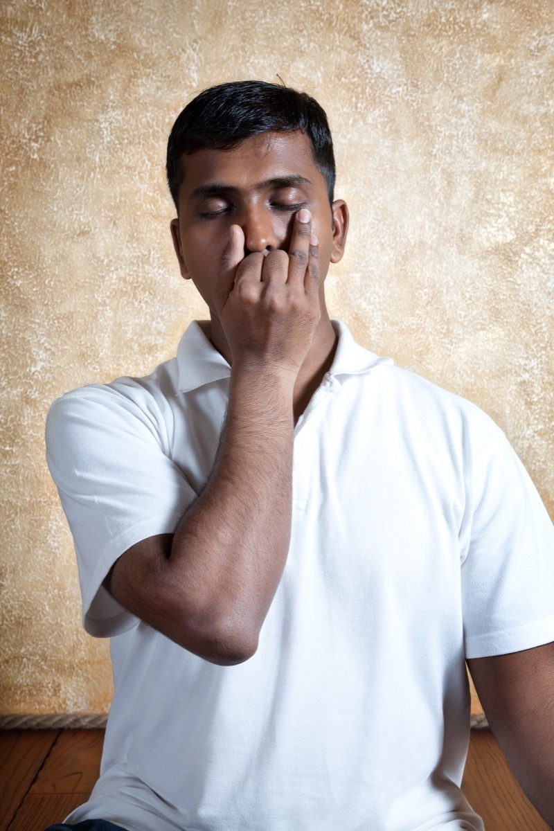 Man holds nostril to stay calm, breathes deeply