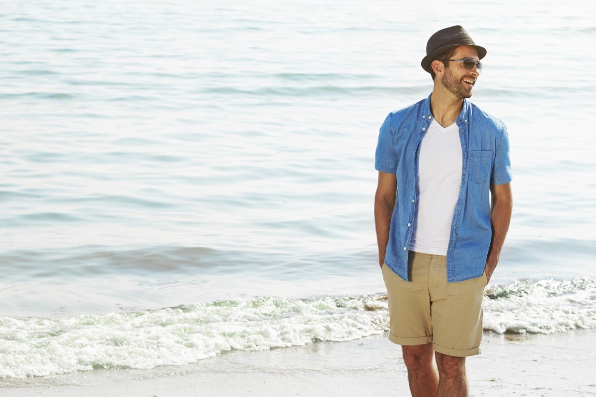 Man on the beach wearing bermuda shorts