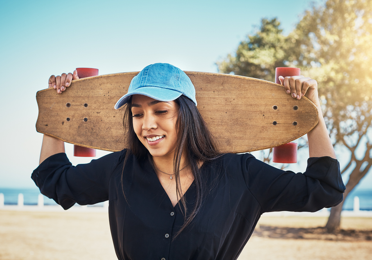 young woman in a baseball hat by the beach