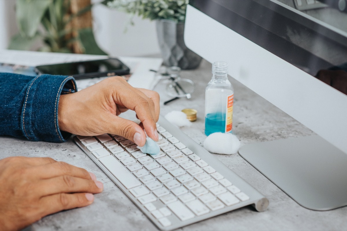 man cleaning his computer keyboard