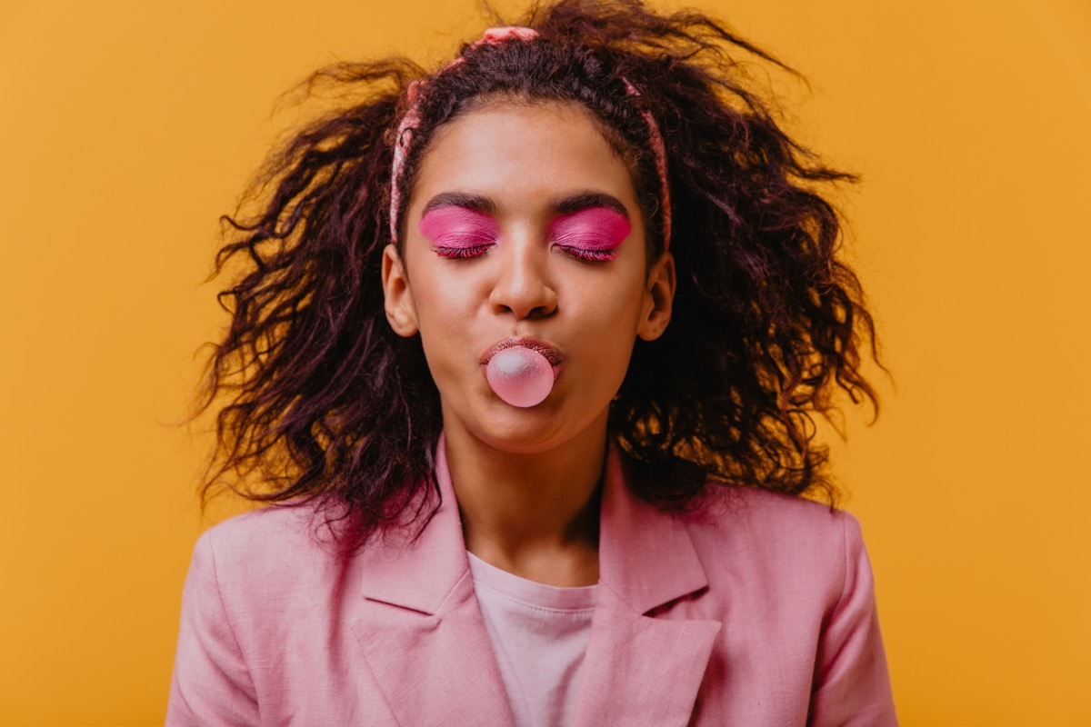 Young black woman blowing bubble with chewing gum