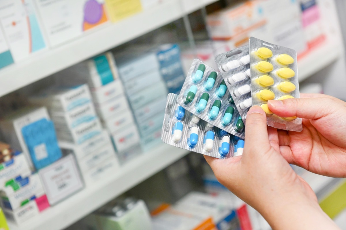 Hand holding medicine capsule pack at the pharmacy drugstore