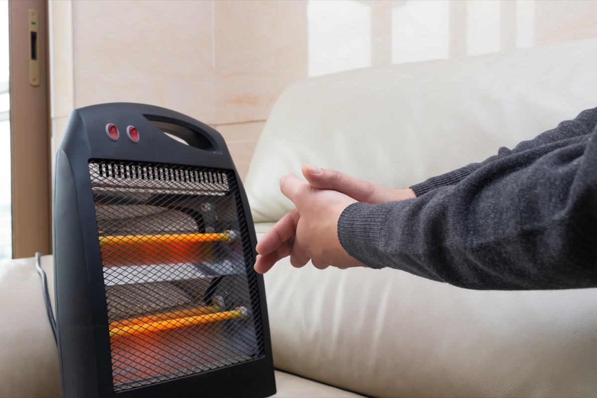 Person Warming Their Hands in Front of an Electric Heater Get Rid of Old Stuff