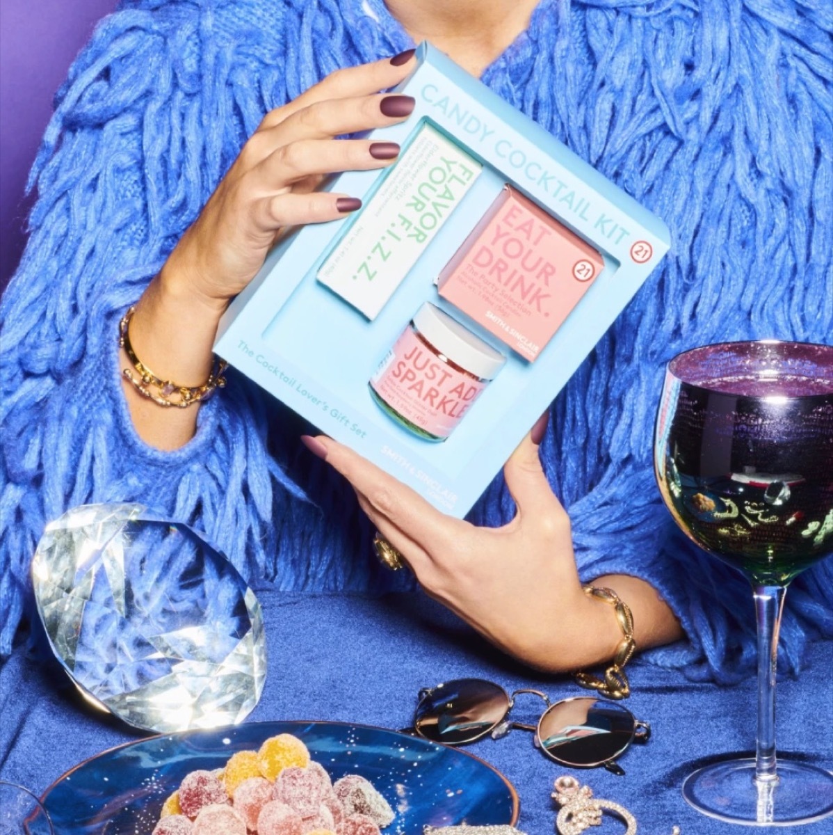 woman in blue holding blue box of cocktail components