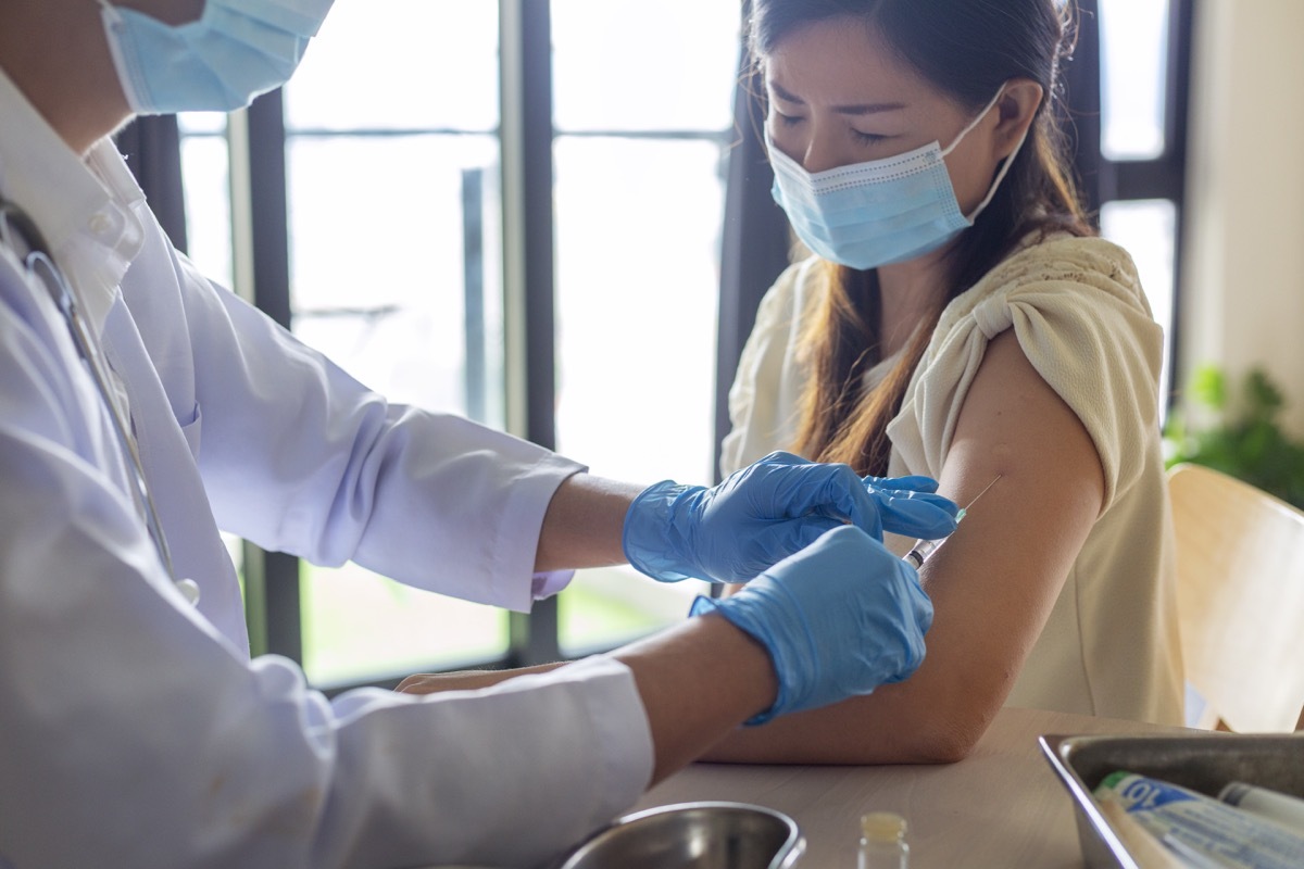 woman getting a vaccine injection from doctor at hospital. Covid-19 vaccine or flu vaccine injection.