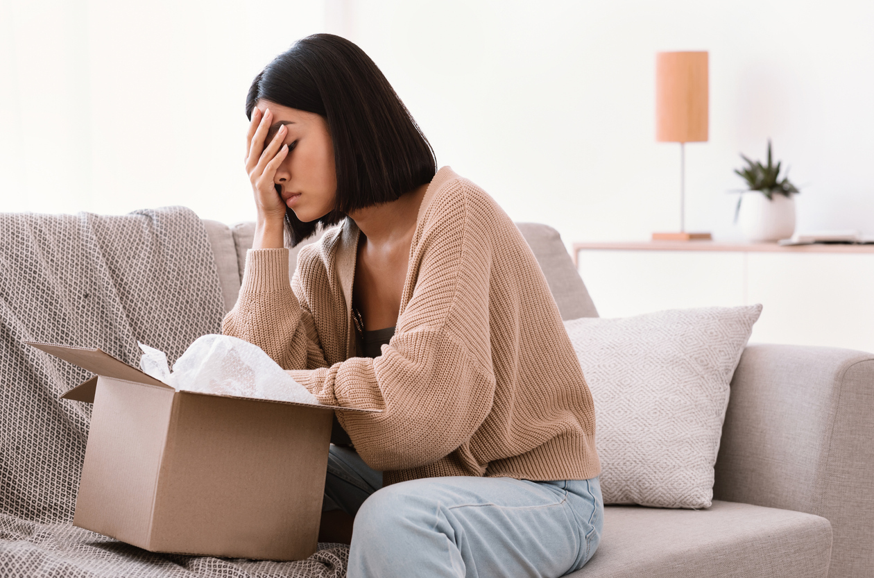 young asian woman upset on couch