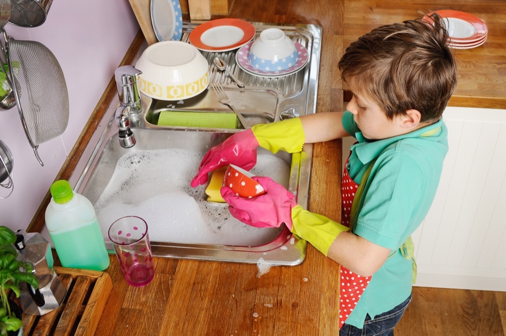 young boy washing dishes