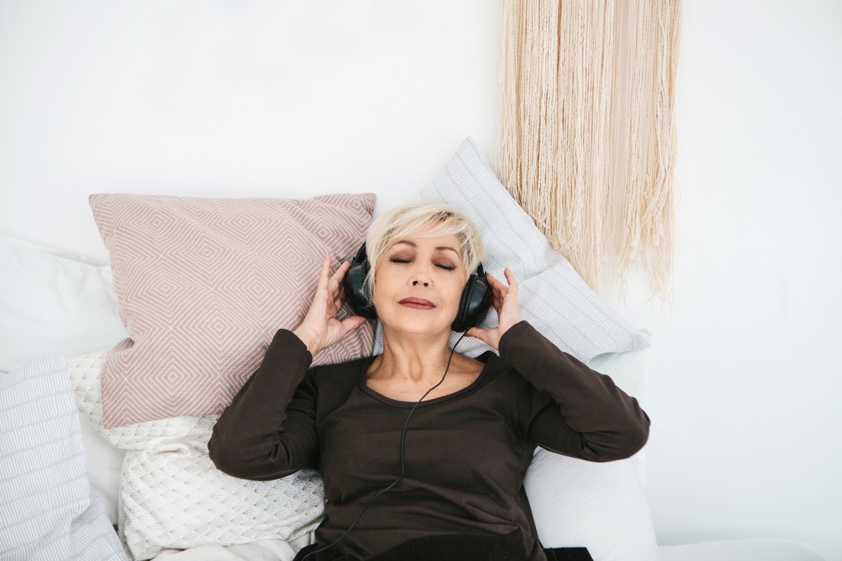 Positive elderly woman listening to music. The older generation and new technologies