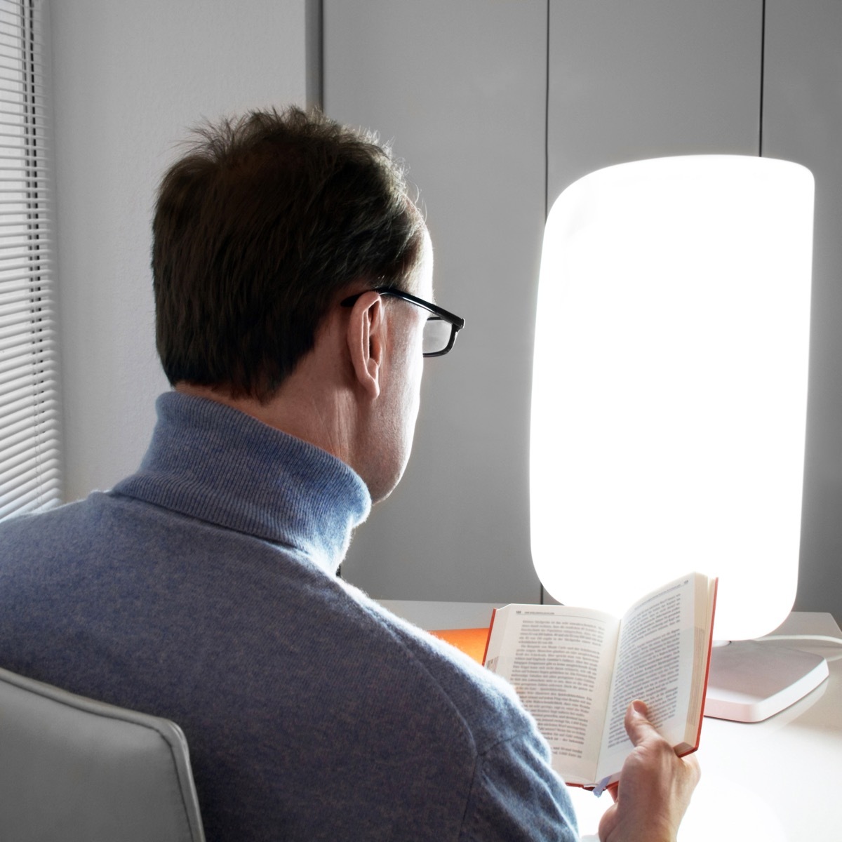 Man using a bright light to beat the winter blues