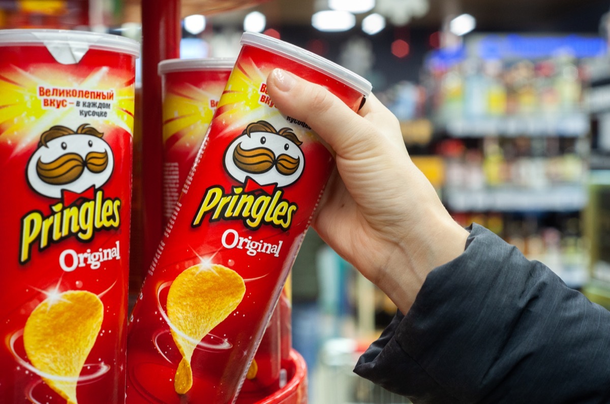 buyer grabbing a Pringles can off the shelf