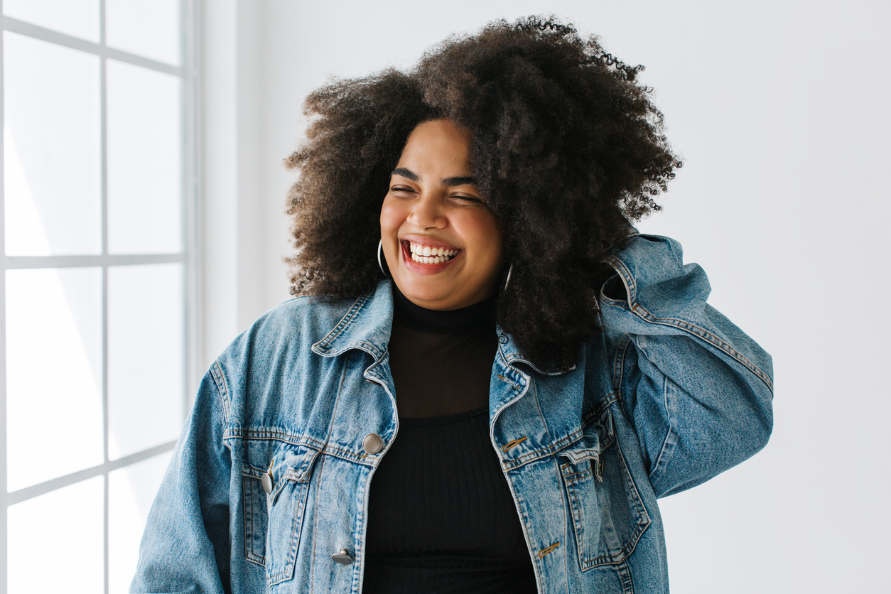 Beautiful woman with jacket smiling in living room. 