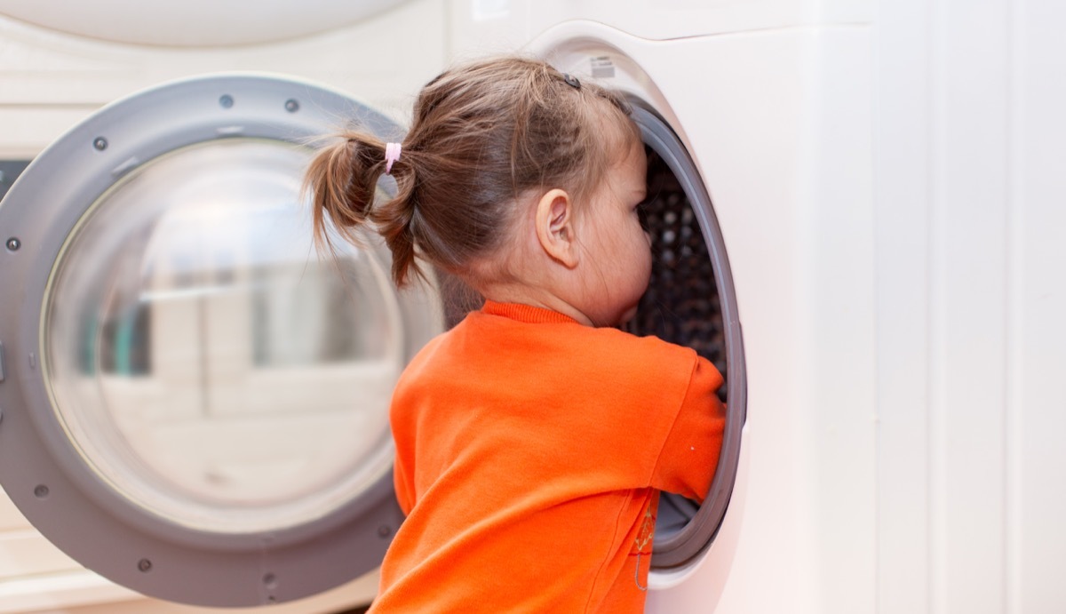 little girl looking into washing machine