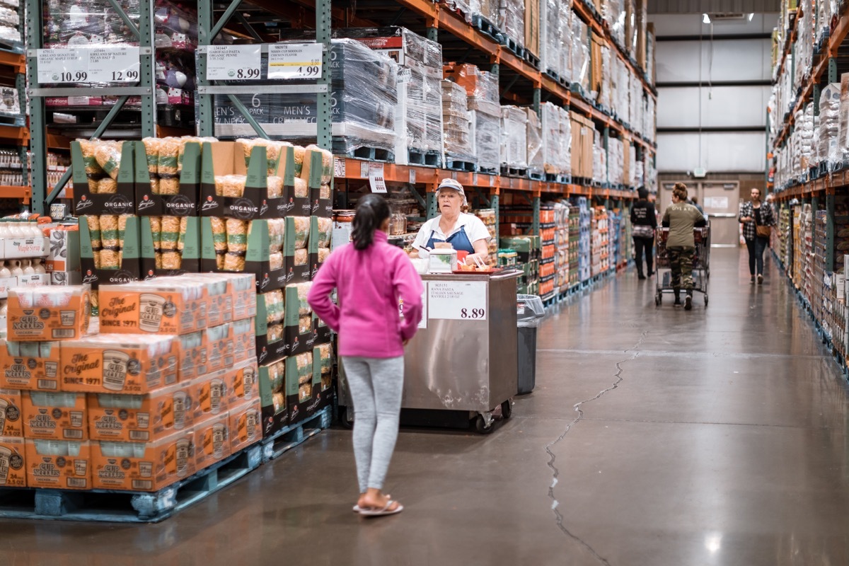 A woman standing in front of a Costco sample station