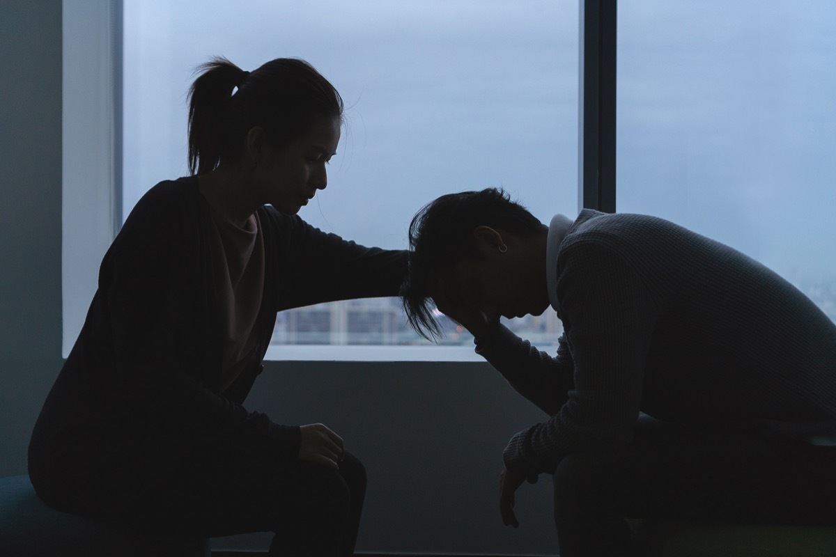 Depressed man and woman in dark room