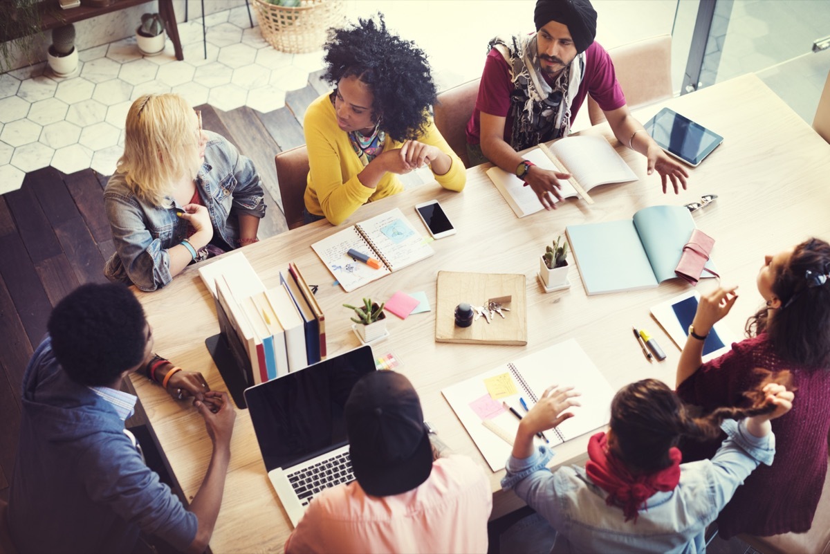 co-workers gathered around a table for a brainstorming meeting