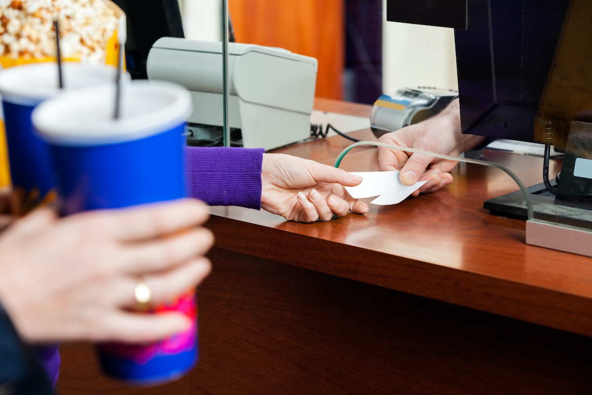 closeup of hand taking movie theater tickets