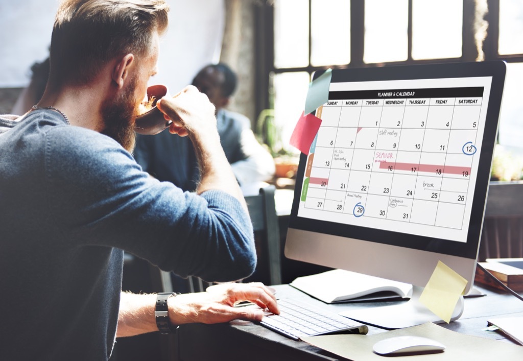 man looking at calendar on computer