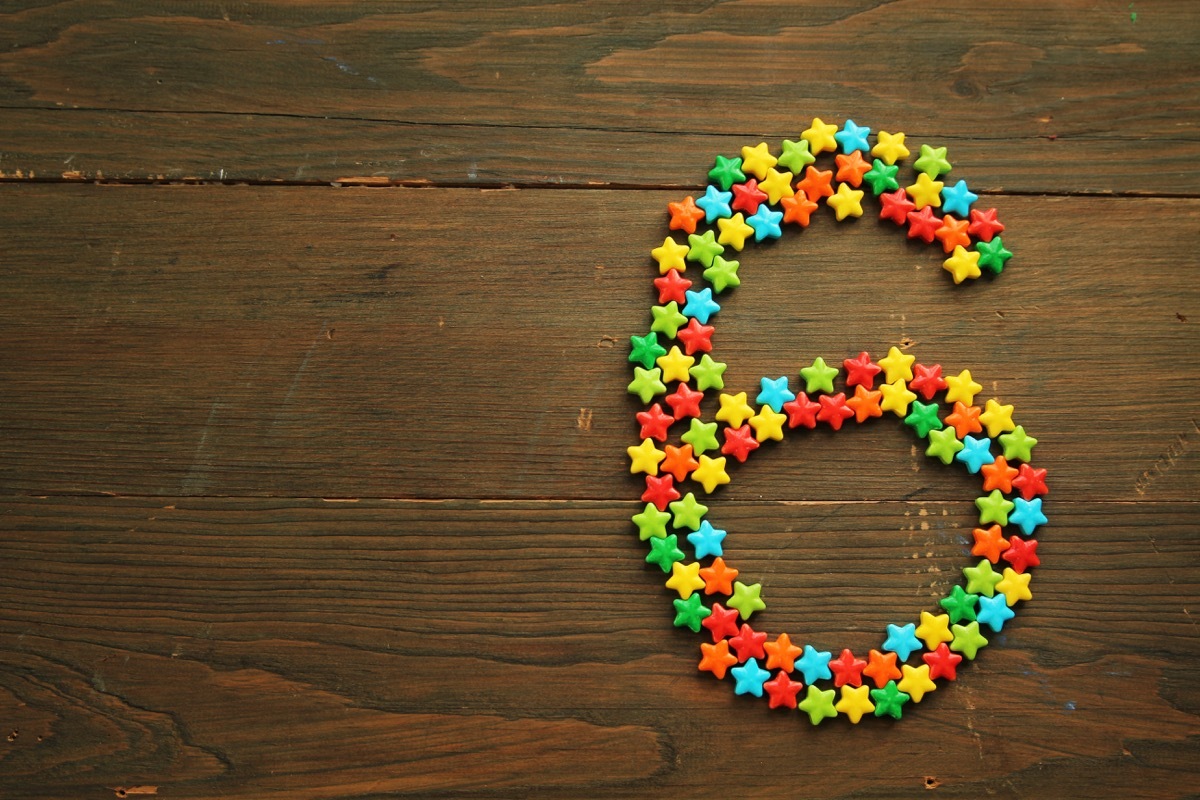 Number six made with star shape candies on a wooden table