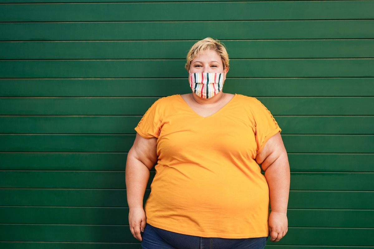 Happy plus size woman wearing a face protective mask during coronavirus outbreak