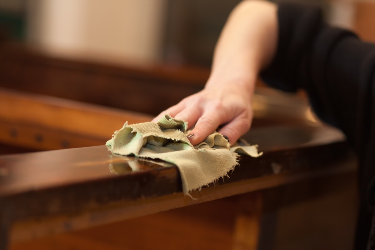 white hand polishing wood