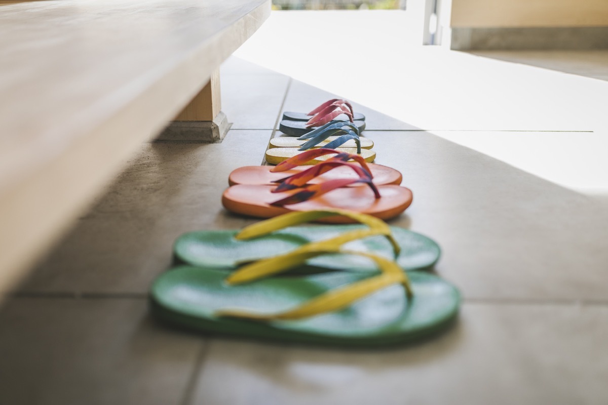 Flip-flops of family in the entrance space of modern house.