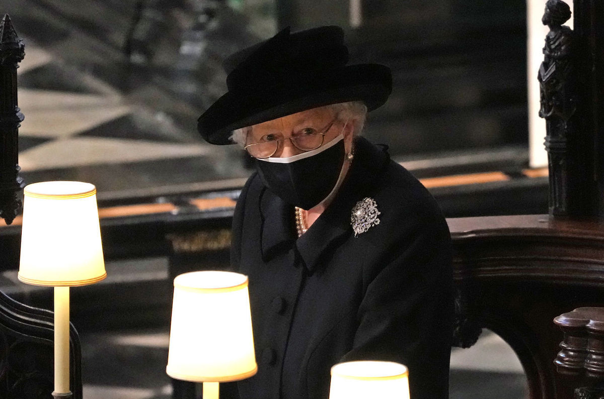 Queen Elizabeth II watches as pallbearers carry the coffin of Prince Philip, Duke Of Edinburgh into St George's Chapel by the pallbearers during the funeral of Prince Philip, Duke of Edinburgh at Windsor Castle on April 17, 2021 in Windsor, United Kingdom