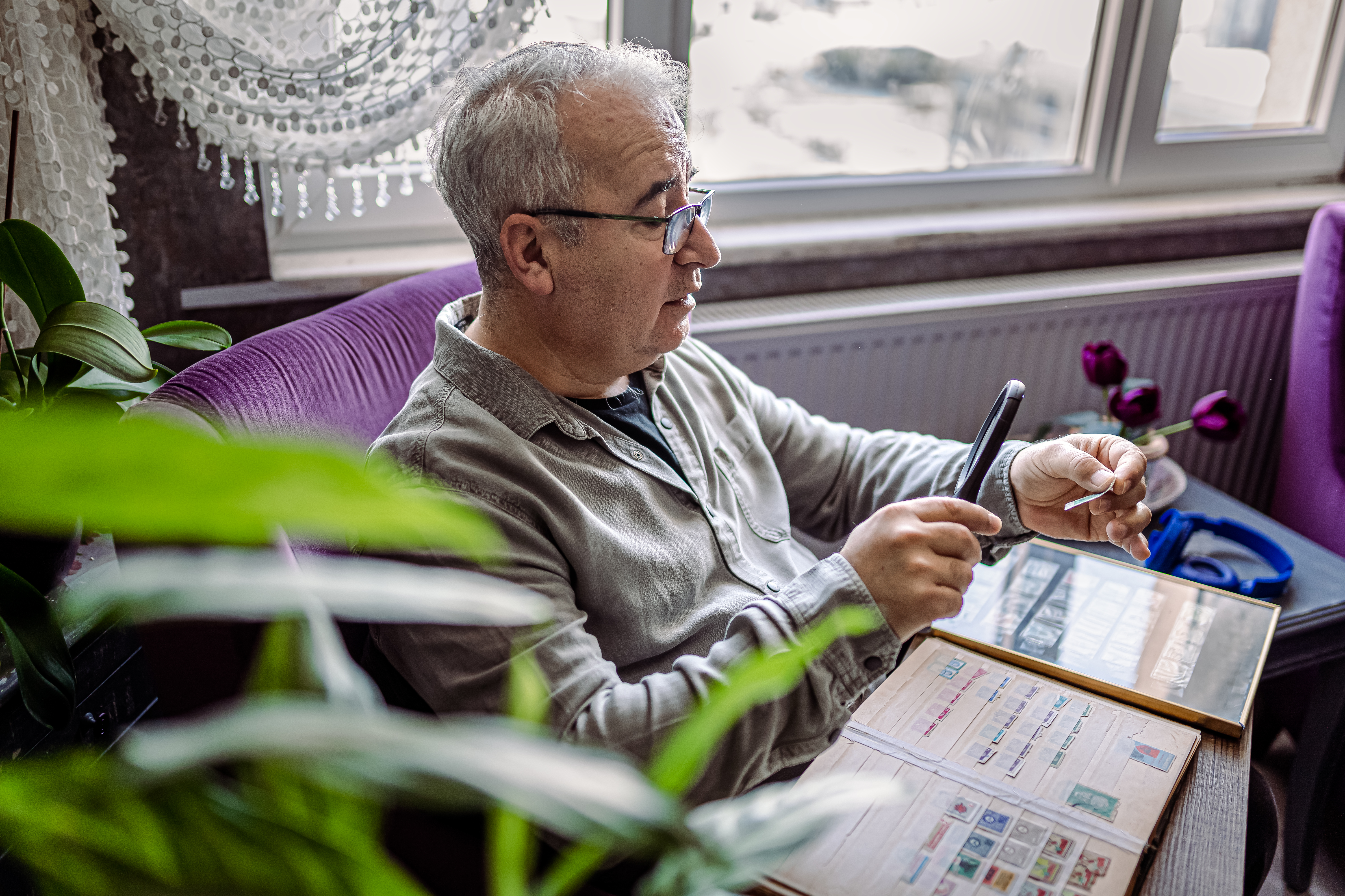 Senior Man collecting stamps from around the world