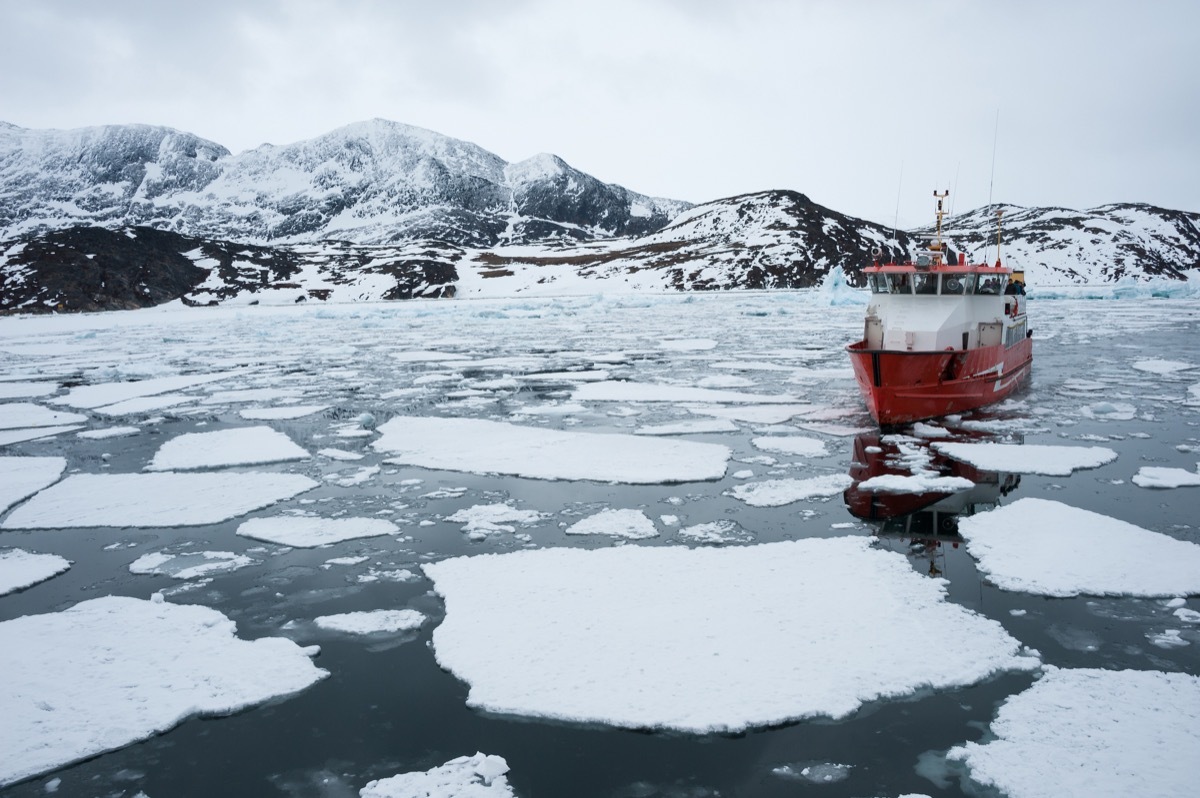 ship sailing through icy ocean in greenland