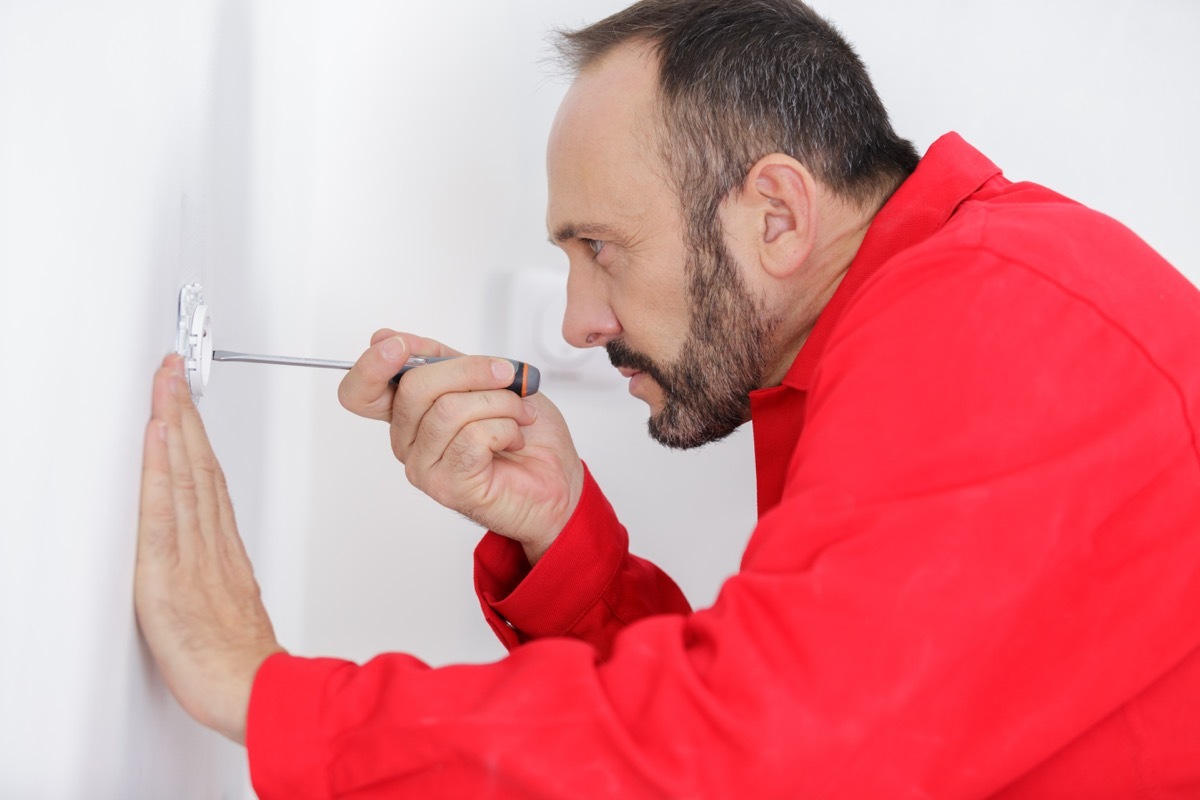 white man fixing outlet