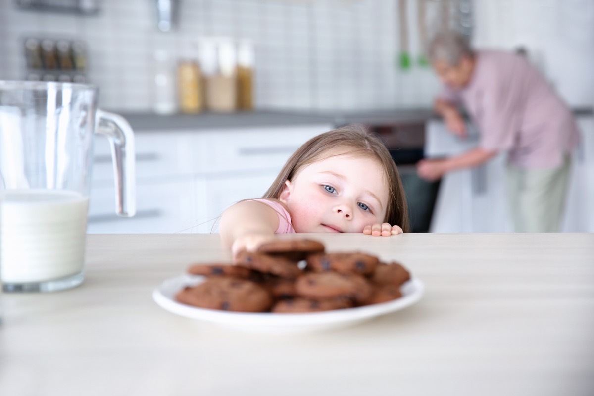 child taking cookie from counter old-fashioned manners