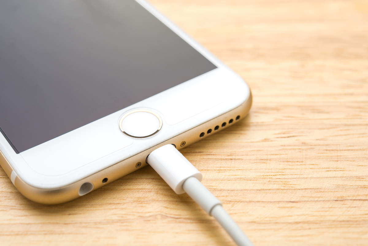 Smartphone charging with power bank on wood board table