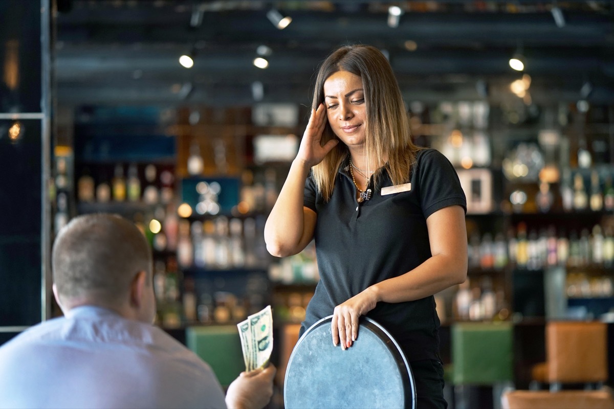 waitress holding tray and looking upset