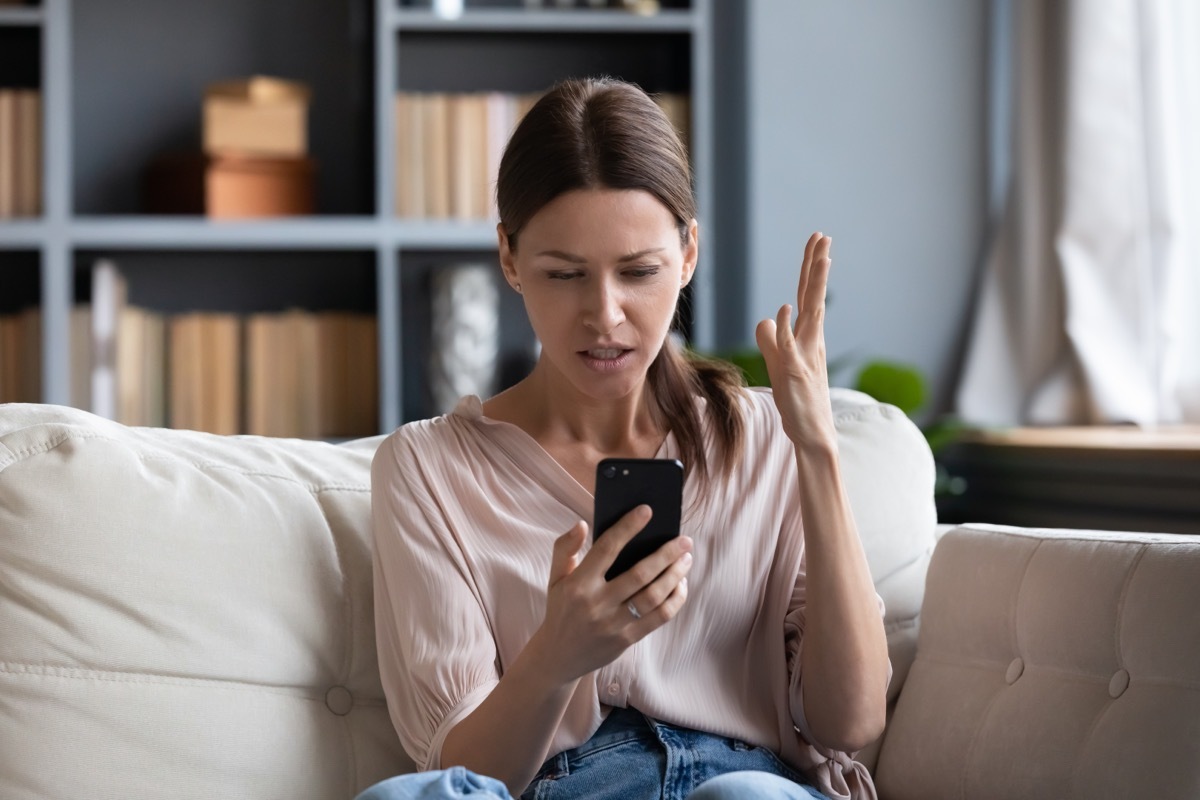 woman on her phone looking annoyed.