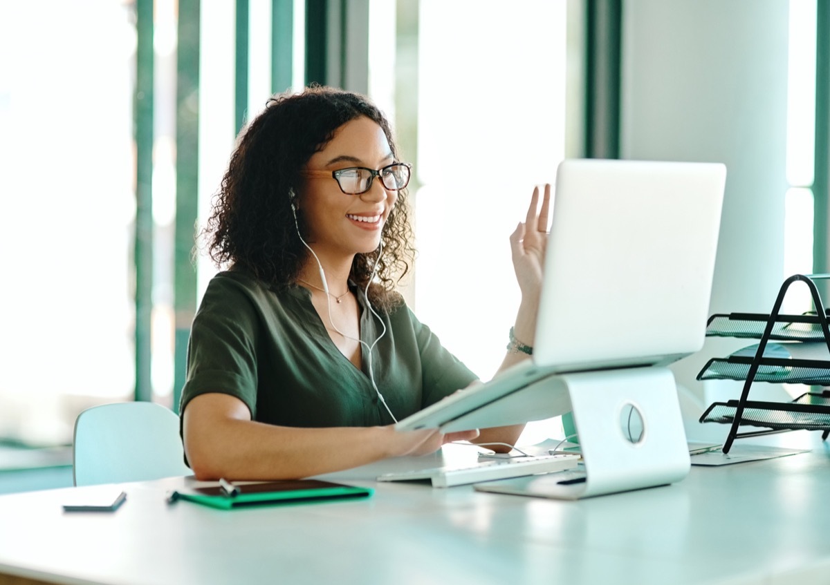 young biracial woman on a video call while sitting at her desk