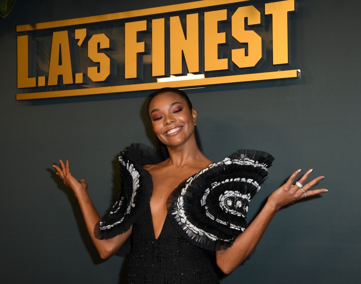 gabrielle union in oversized plunging top in front of la's finest sign