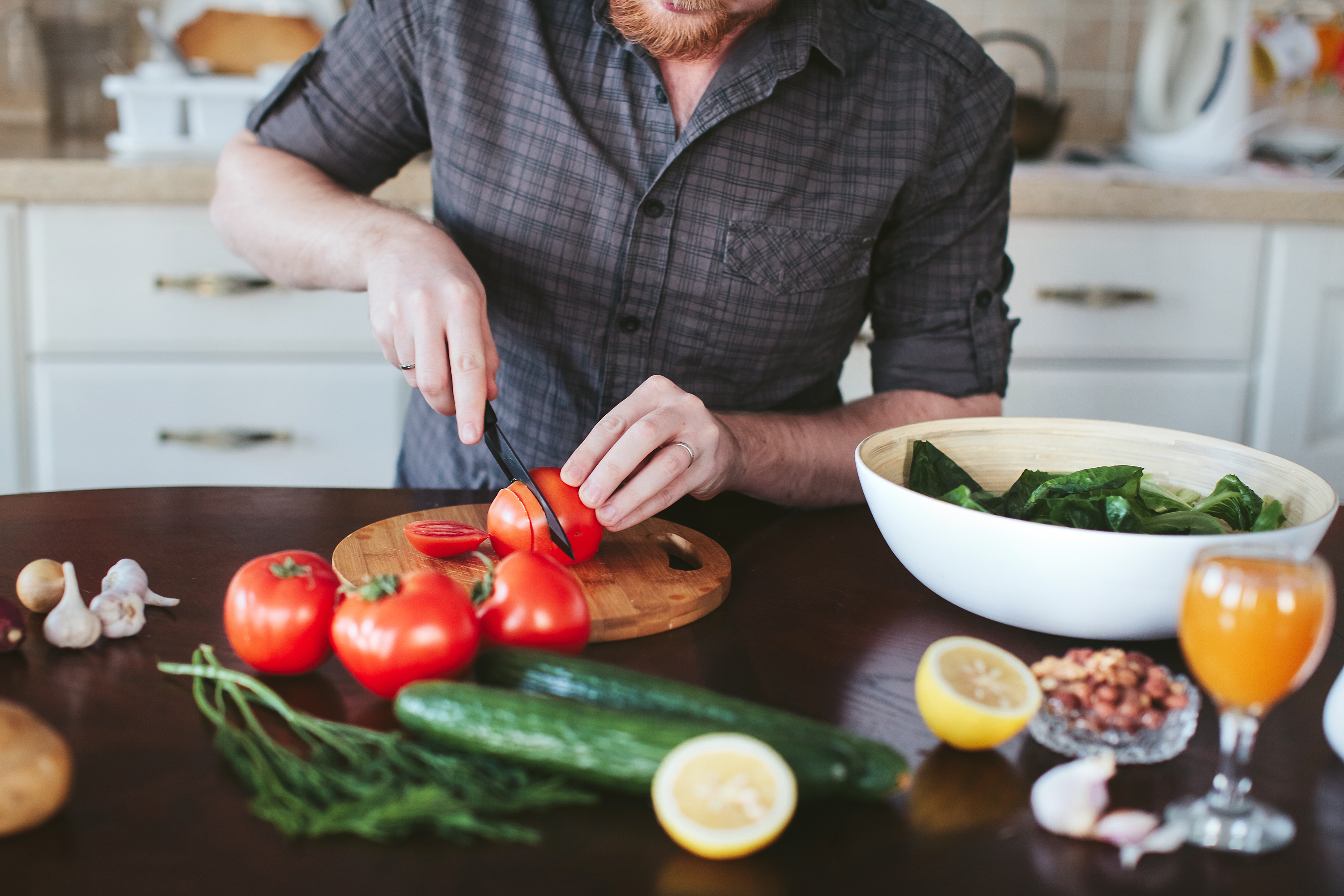 man cutting tomatoes in the kitchen, what he wants you to say