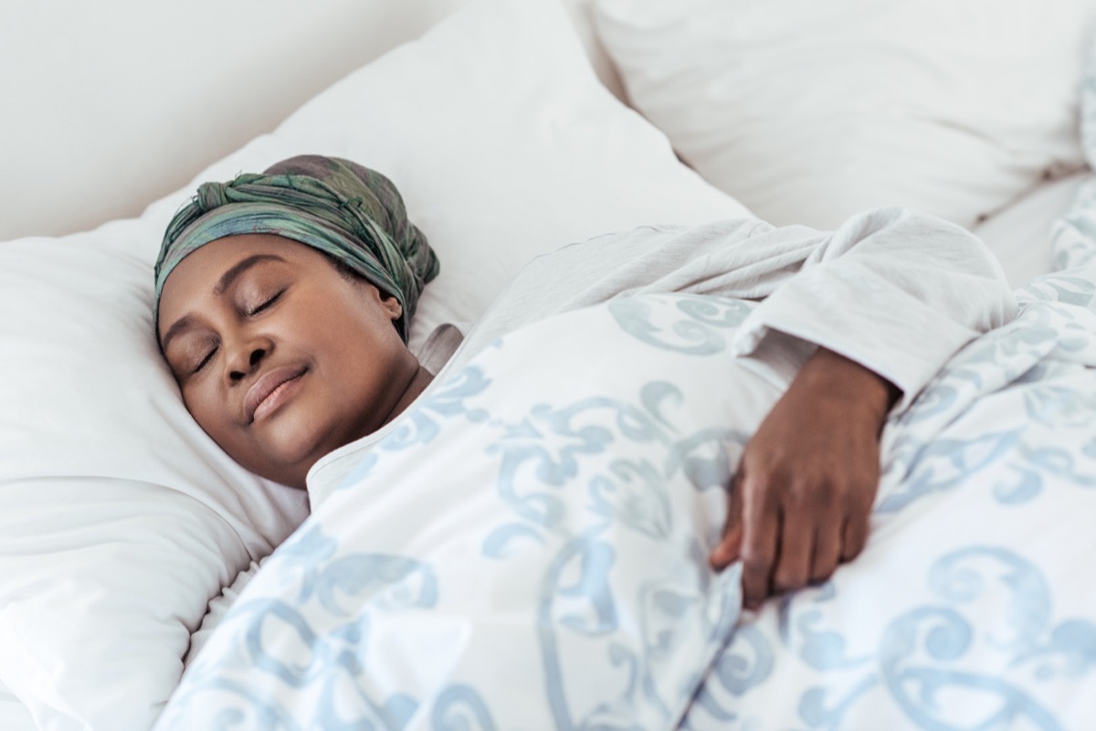 woman sleeping in her bed habits that slow down aging