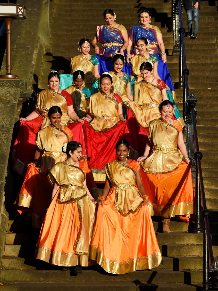 a group of women dressed in traditional indian garb on steps