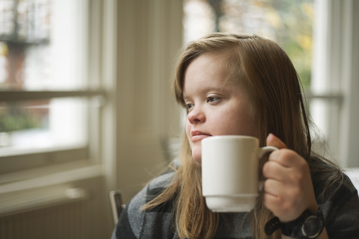 Girl with down syndrome having breakfast.