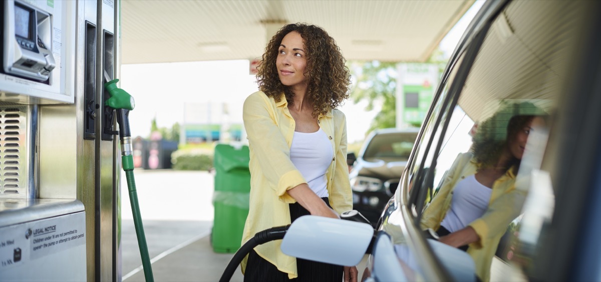 woman smiling at gas pump