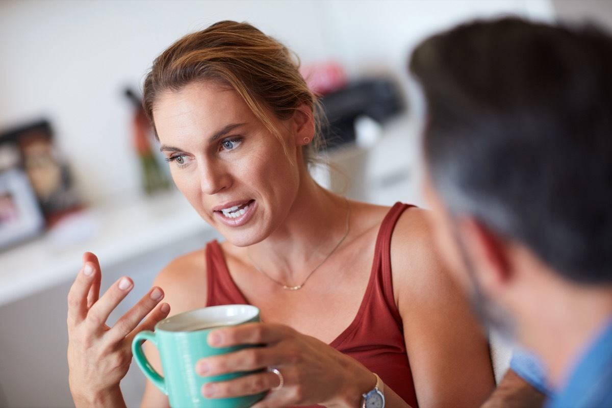 cropped shot of a woman asking a man questions over a cup of coffee