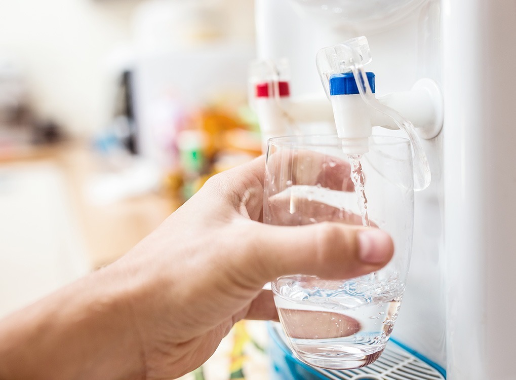 man getting water from a water cooler