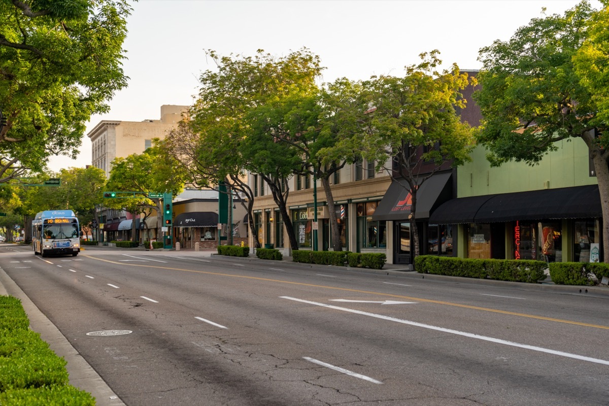 bus driving down street, fullerton, california, street lined with trees